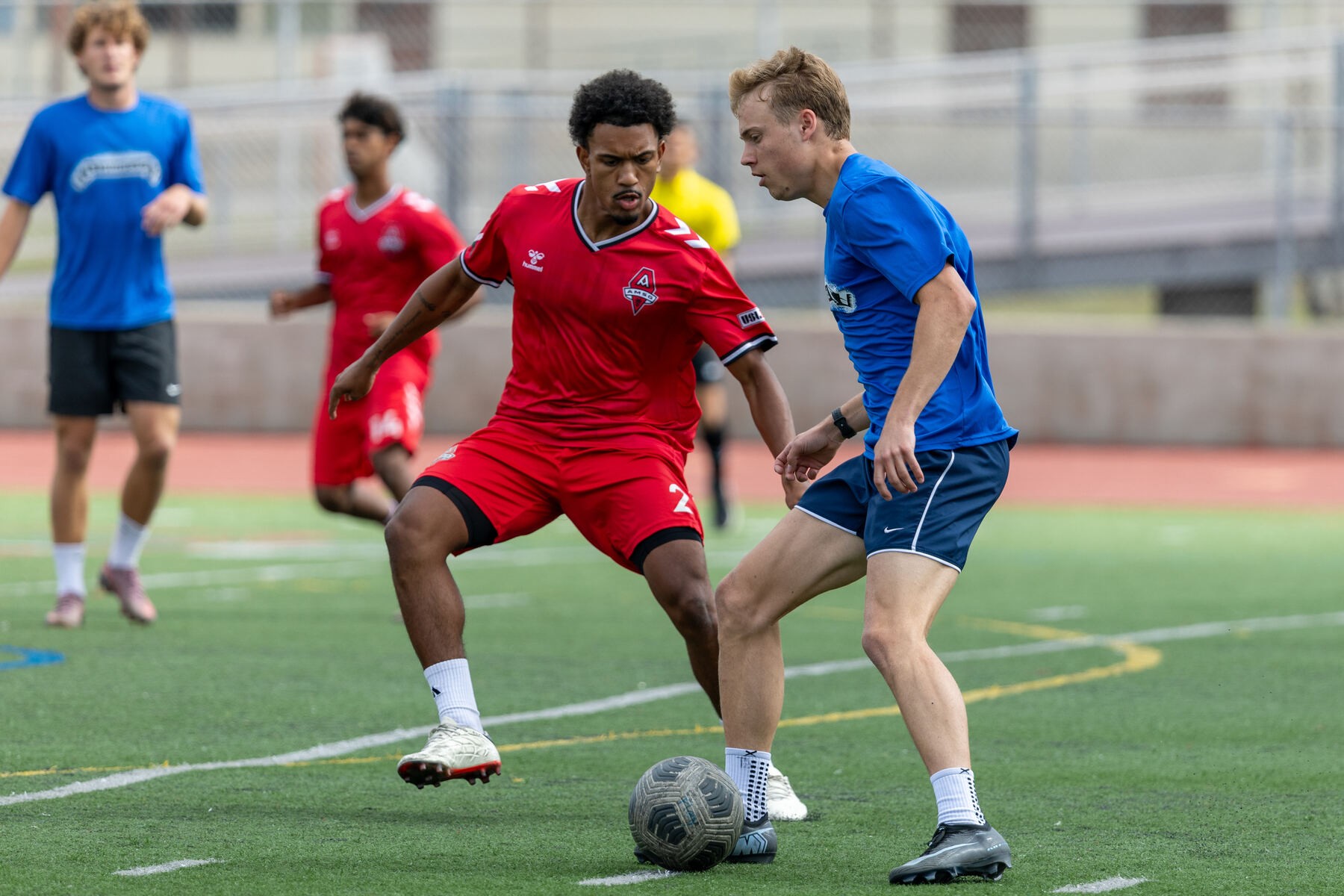 Men's athlete shielding the ball from a defender